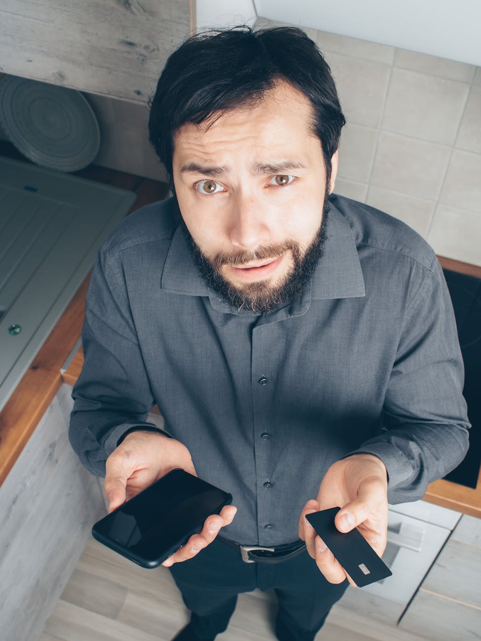 Confused person holding credit card and looking at phone