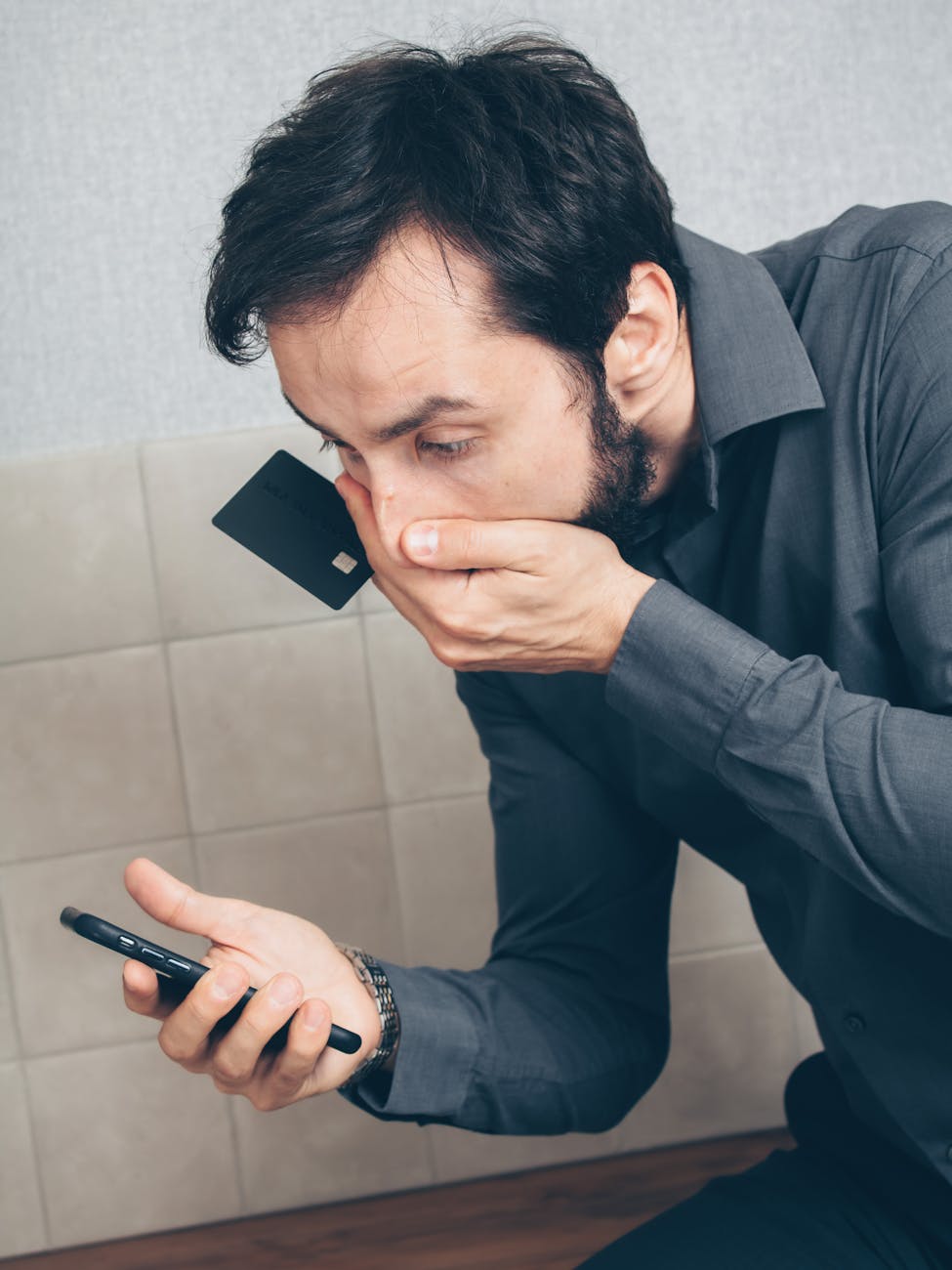 Person concerned about potential credit card fraud while using smartphone